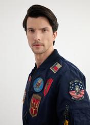 Pánska pilotná bunda TOP GUN v námorníckej modrej farbe KURMT-0381-69(W25) - detailný záber prednej strany na modelke na bielom pozadí.