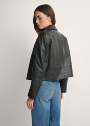 Čierna krátka dámska kožená bunda KURDS-0598-99(W26), pohľad na produkt zozadu na modelke, viditeľná polovica siluety.