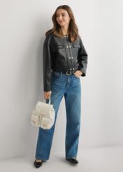 Dámsky prešívaný batoh TOREC-1195-0A(W26) v krémovej farbe - pohľad spredu na produkt, ktorý drží modelka, na svetlom pozadí. Viditeľná je celá silueta.