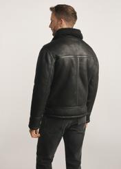 Klassischer schwarzer Herren-Lammfellmantel KOZMP-0001A-99(Z24), Produkt von hinten am Model sichtbar, die Hälfte der Silhouette sichtbar.
