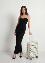 Malý bodkovaný kufor na kolieskach WALAB-0074-0P-19(W26), diagonálny pohľad na produkt vedľa siluety modelky.