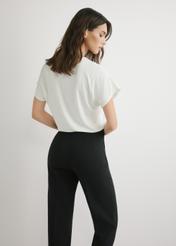 Dámska blúzka krémovej farby BLUDT-0206-0B(W26), pohľad zozadu na modelku. Viditeľná polovica siluety.