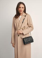 Malá prešívaná dámska kabelka v čiernej farbe TOREC-1150-99(W26), pohľad spredu na produkt na modelke, viditeľná polovica siluety.