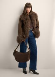 Dámska hnedá semišová kabelka hobo TORES-1384-1I(Z26) - pohľad spredu na produkt, ktorý drží modelka, na bielom pozadí. Viditeľná je silueta celého tela.