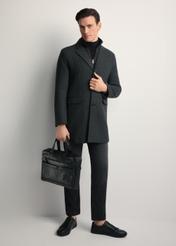 Čierna kožená pánska aktovka TORMS-0415A-99(Z25) - diagonálny pohľad na produkt, ktorý drží modelka, na bielom pozadí. Viditeľné celé telo.