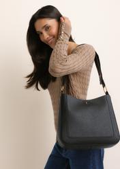 Čierna dámska hobo taška TOREC-1257-9I(Z26), diagonálny pohľad na produkt, na modelke, na svetlom pozadí. Viditeľná polovica siluety.