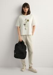 Čierny nylonový dámsky batoh TOREN-0341-99(W26), pohľad na produkt v ruke modelky. Viditeľné celé telo.