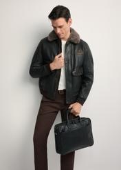 Čierna kožená pánska taška TORMS-0299A-99(Z25) - diagonálny pohľad na produkt, ktorý drží modelka, na bielom pozadí. Viditeľné celé telo.