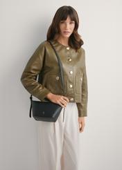 Malá čierna kabelka z prírodnej kože TORES-1267-9I(W26), pohľad spredu na produkt na modelke, viditeľná polovica siluety.