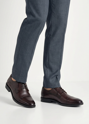 Pánske hnedé kožené topánky BUTYM-0483-1I(W26), pohľad na produkt na nohách modelu, na svetlom pozadí.