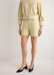 Dámske kožené svetložlté šortky SPODS-0035-2A(W26), pohľad na produkt spredu na modelke, viditeľná polovica siluety.