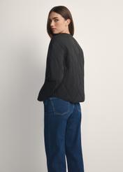 Čierna dámska prechodná nylonová bunda KURDT-0656-99(W26), pohľad na produkt zozadu na modelke, viditeľná polovica siluety.