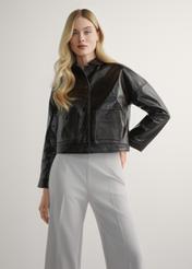 Dámska hnedá krátka kožená bunda KURDS-0593-1I(W26) - pohľad spredu na výrobok, na modelke, na svetlom pozadí. Viditeľná silueta po kolená.