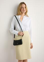 Malá čierna dámska kabelka TOREC-1188-99(W26) - pohľad spredu na produkt, na modelke, na svetlom pozadí. Viditeľná silueta po polovičnú dĺžku.