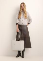 Veľká krémová dámska shopper taška TOREC-1309-0B(Z26), pohľad spredu na produkt, na modelke, na svetlom pozadí. Je viditeľná celá silueta.