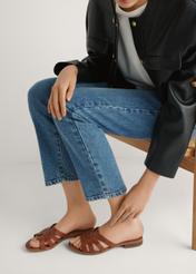 Dámske kožené šľapky v koňakovej farbe BUTYD-1266-1F(W26), bočný pohľad na produkt na nohách modelky, na svetlom pozadí.