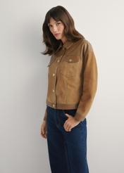 Beige Damen-Lederjacke KURDS-0572-1B(W26) – Seitenansicht des Produkts vor hellem Hintergrund. Die Silhouette ist zur Hälfte sichtbar.