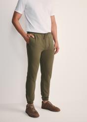 Pánske khaki tepláky SPOMT-0101-55(Z25), pohľad spredu na produkt na modelke. Viditeľná polovica siluety.