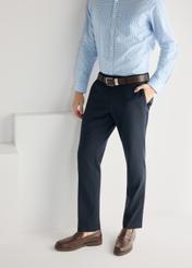 Pánske tmavohnedé kožené mokasíny BUTYM-0502-1I(W26), bočný pohľad na produkt na nohách modelky, na svetlom pozadí.