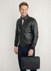 Čierna taška na notebook TORMN-0398-9J(W26) - pohľad spredu na produkt, ktorý drží modelka, na svetlom pozadí. Viditeľná silueta po kolená.