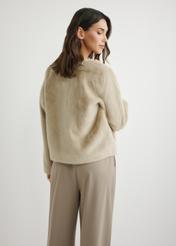 Dámsky krátky béžový kožuch FUTDP-0079-1A(W26), pohľad na modelku zozadu. Viditeľná polovica siluety.