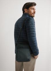 Pánska čierna crossbody kabelka TORMN-0395-9J(W26) - pohľad na produkt spredu, na modelke, na svetlom pozadí. Viditeľná silueta po pás.