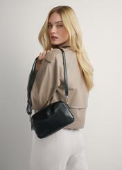 Stredne veľká čierna dámska kabelka TOREC-1121-9F(W26), pohľad na produkt na ramene modelky. Viditeľná polovica siluety.