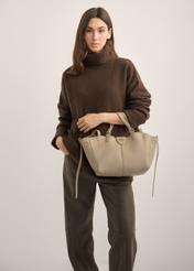 Dunkelbeige Damenhandtasche TOREC-1231-1K(Z26). Produktansicht von vorn an einem Model, die Silhouette ist zur Hälfte sichtbar.
