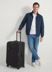 Veľký kufor na kolieskach WALNY-0046-99-28(W26), diagonálny pohľad na produkt vedľa siluety modelky.