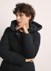Dlhá čierna dámska bunda KURDT-0602-99(Z25), pohľad spredu na produkt na modelke. Viditeľná polovica siluety.