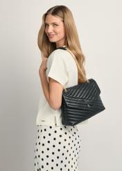 Čierna kožená dámska kabelka s prešívaním TORES-1286-99(W26), pohľad spredu na produkt na modelke, viditeľná polovica siluety.