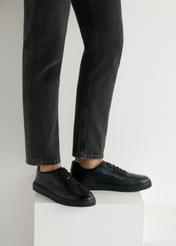 Čierne kožené pánske športové topánky BUTYM-0484-99(W25), bočný pohľad na produkt na modeli, viditeľná polovica siluety.