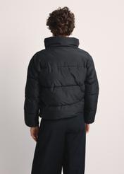 Dámska krátka čierna bunda KURDT-0601-99(Z25), pohľad na produkt zozadu na modelke. Viditeľná polovica siluety.