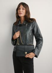 Čierna dámska taška cez rameno TOREC-1137-99(W26), pohľad na produkt v rukách modelky. Viditeľná polovica siluety.