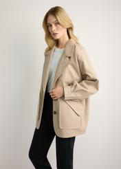 Dámska béžová kožená bunda oversize KURDS-0577-1B(W26) - bočný pohľad na produkt, na modelke, na svetlom pozadí. Viditeľná silueta po kolená.