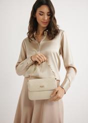 Dámska tkaná kabelka krémovej farby TOREC-0767-0P(W26) - pohľad na produkt, ktorý drží modelka na svetlom pozadí. Viditeľná je silueta po pás.