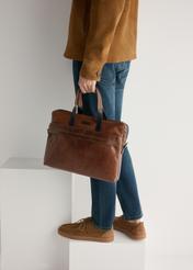 Pánske semišové topánky BUTYM-0532-1D(W26) v tmavej farbe, bočný pohľad na produkt na nohách modelky, na svetlom pozadí.