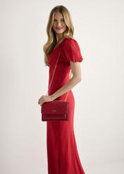 Červená dámska kabelka s monogramom TOREC-1155-4B(W26), pohľad spredu na produkt na modelke, viditeľná polovica siluety.