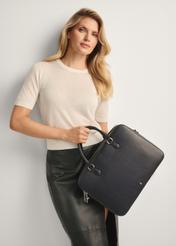 Čierna kožená taška na notebook TORES-1222-99-9I(W26) - pohľad spredu na produkt, pričom modelka ho drží v ruke. Viditeľná silueta po kolená.