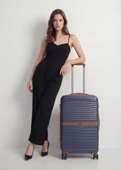 Stredný kufor na kolieskach WALAB-0084-7D-24(W26), pohľad spredu na produkt vedľa siluety modelky.