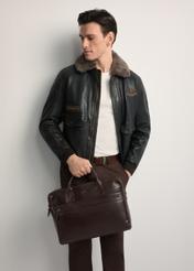 Hnedá kožená pánska taška TORMS-0460-89(Z25) - pohľad spredu na produkt, ktorý drží modelka. Viditeľná polovica siluety.