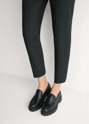 Dámske čierne kožené mokasíny BUTYD-1069-99(W26) - pohľad spredu na výrobok, na modelke, na svetlom pozadí. Viditeľná silueta po kolená.