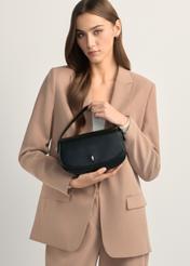 Malá čierna dámska taška cez rameno TOREC-1185-99(W26), pohľad na produkt v rukách modelky. Viditeľná polovičná silueta.