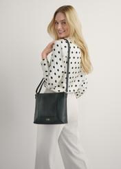 Čierna kožená dámska kabelka TORES-1265-9I(W26) - pohľad spredu na produkt, na modelke, na svetlom pozadí. Viditeľná silueta po kolená.