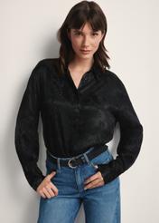 Dámska čierna košeľa so zvieracou potlačou KOSDT-0174-51(Z25), pohľad spredu na produkt na modelke. Viditeľná polovica siluety.