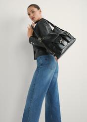 Dámsky batoh TOREC-1193-99(W26) čiernej farby - pohľad na produkt mierne diagonálny, na svetlom pozadí. Viditeľná silueta po kolená.