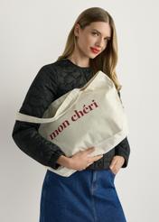 Béžová bavlnená nákupná taška TOREN-0334-0P(W26), pohľad na produkt v ruke modelky. Viditeľná polovica siluety.