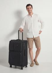 Veľký kufor na kolieskach WALNY-0048-99-28(W26), diagonálny pohľad na produkt vedľa siluety modelky.