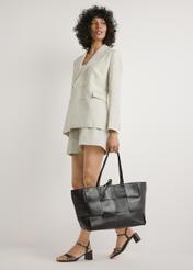 Veľká hnedá kožená dámska kabelka TORES-1299-1H(W26) - pohľad spredu na produkt, ktorý drží modelka, na bielom pozadí. Viditeľná je silueta celého tela.