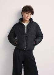 Dámska krátka čierna bunda KURDT-0601-99(Z25), pohľad spredu na produkt na modelke. Viditeľná polovica siluety.